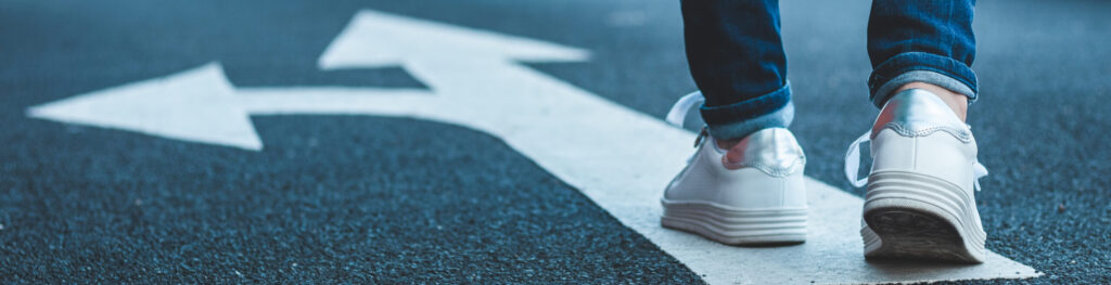 Person walking over a directional road marking